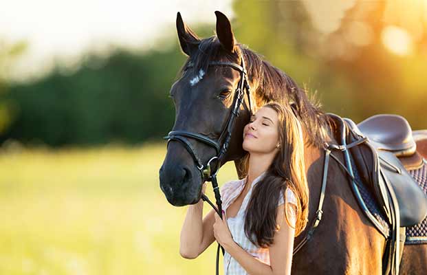 Un cavallo e una donna nella luce della sera