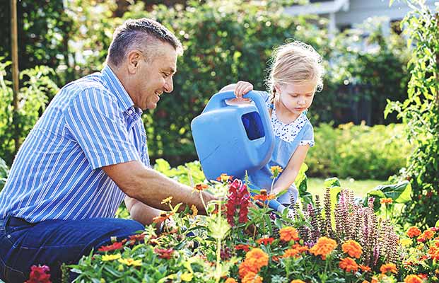 Padre e figlia lavorano nel giardino fiorito