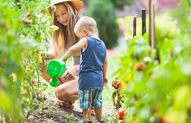 Madre e figlio innaffiano i fiori