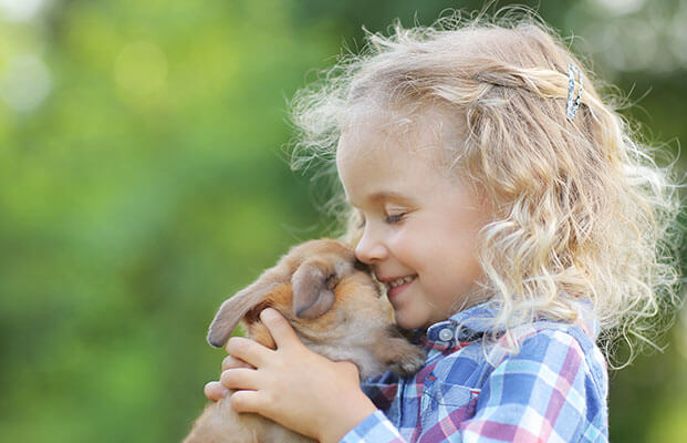 Bambino con in mano una lepre