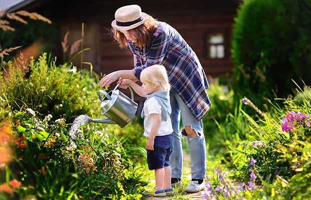 Madre e figlia innaffiano il giardino