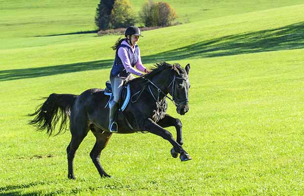 Donna al galoppo su un prato